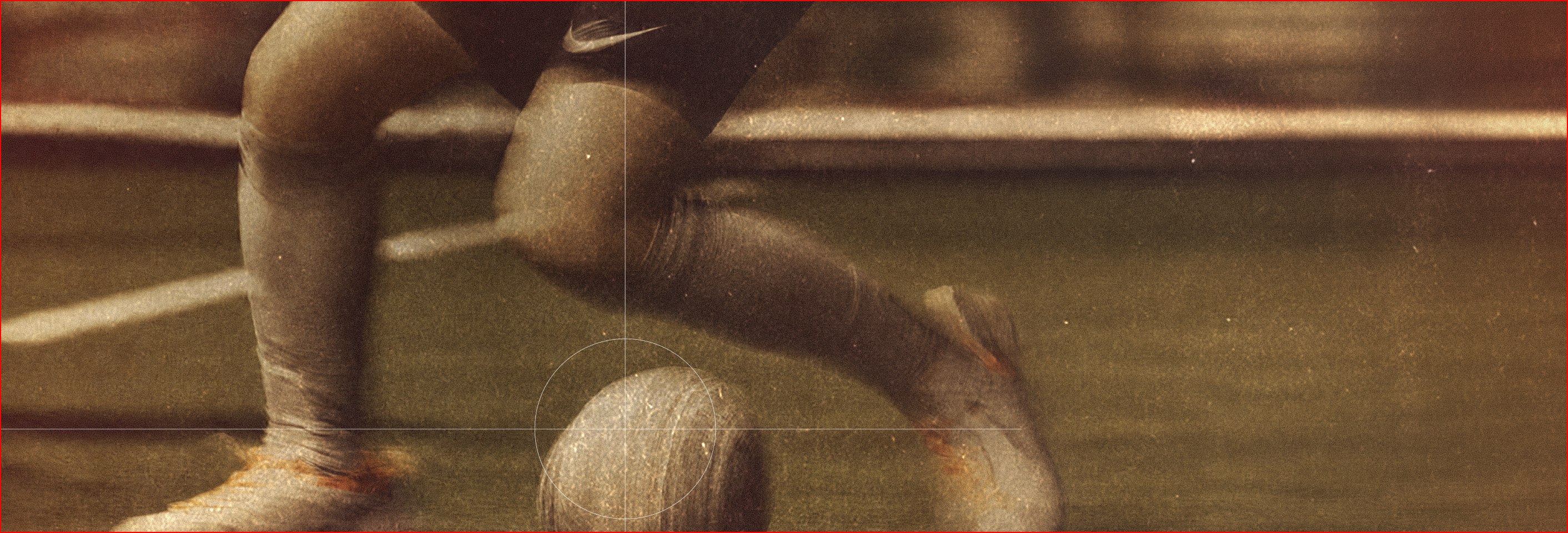 Footballer crouching beside the ball on the pitch